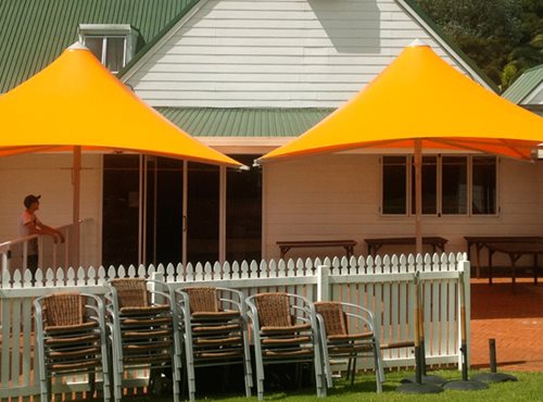 Orange Parasol Umbrella's shading an outside area in front of a building